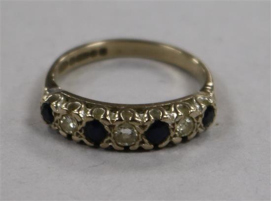 A 1970s 18ct gold and graduated seven stone sapphire and diamond half hoop ring, size N.